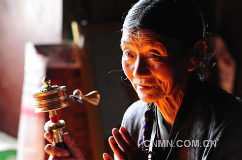 一名藏族老人在西藏自治區(qū)山南地區(qū)昌珠寺手搖轉(zhuǎn)經(jīng)筒，虔誠地誦念佛經(jīng)