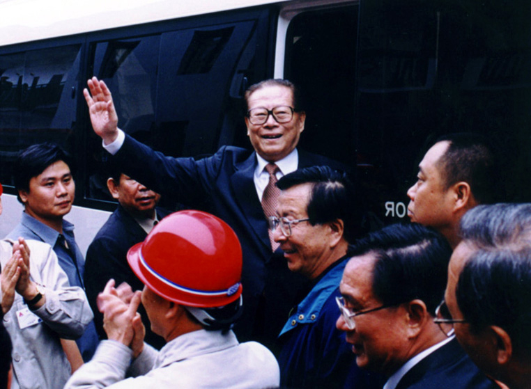 “同志們好！”“大家好！”邁出車門的江澤民向激動沸騰的西南鋁職工微笑地點頭，爽朗地問好，親切地揮手致意。（李影攝）
