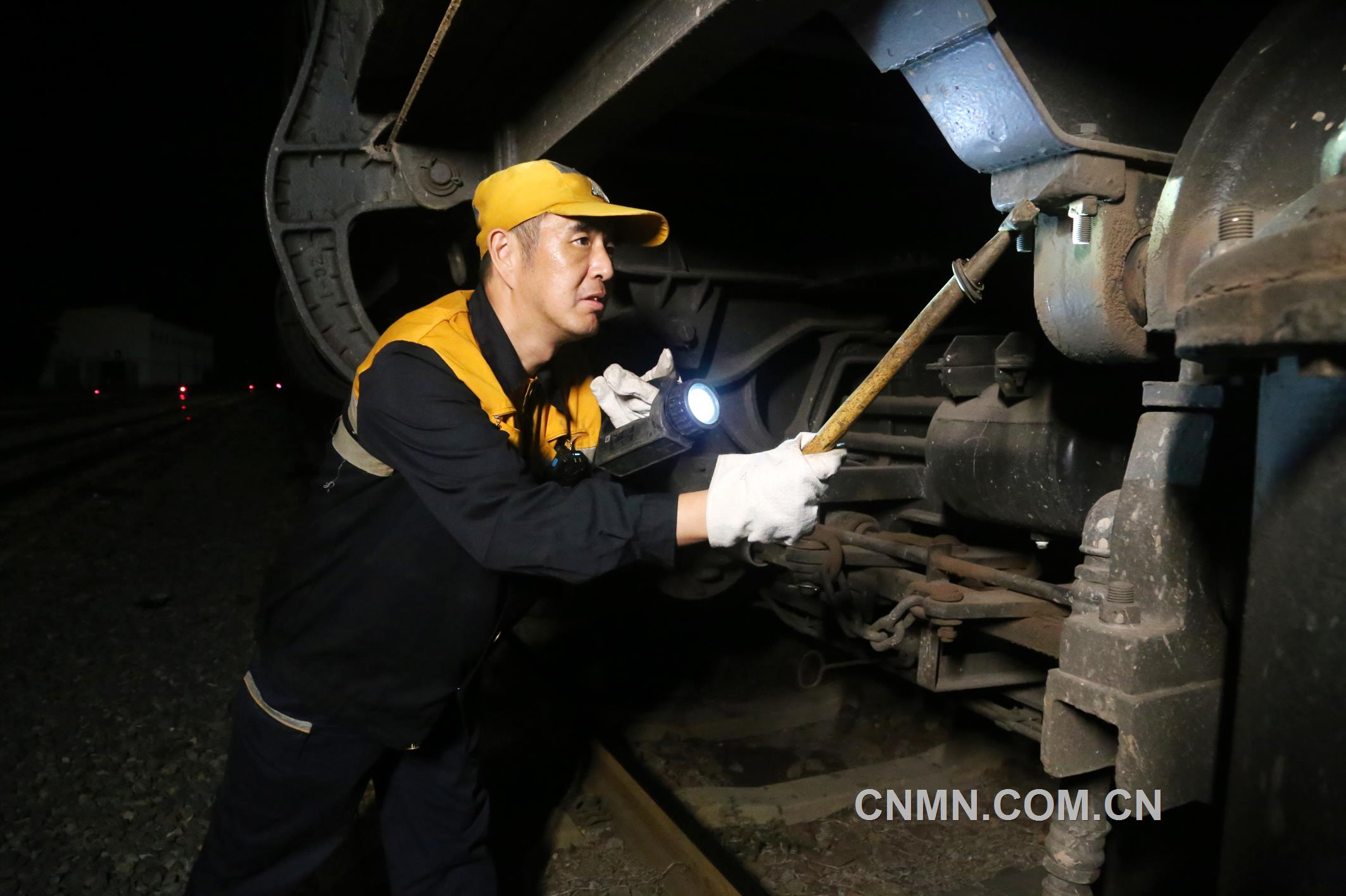 焦建智正在對待發(fā)礦石專列進(jìn)行發(fā)車前的技術(shù)檢查。